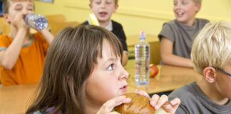 Niños desayunando en el colegio con pan